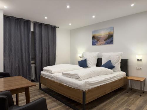a bedroom with a large bed and a table at Hotel Zur Post in Haren