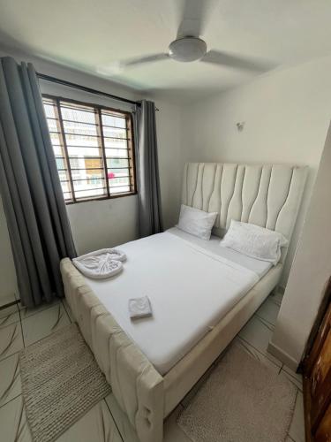 a large bed in a room with a window at Azure Coast retreat in Watamu