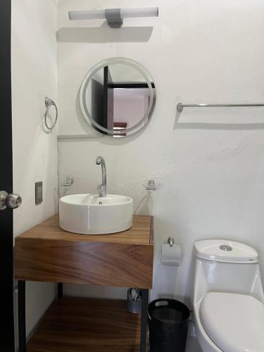 a bathroom with a sink and a mirror and a toilet at Valle Stay in Cedro