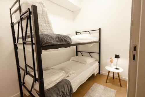 a room with two bunk beds and a table at P&G Apto 203-Bagnoregio in Caxias do Sul