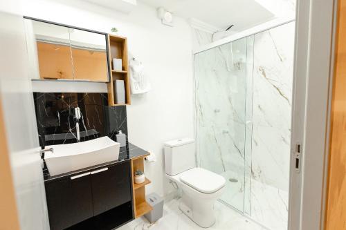a bathroom with a toilet and a sink and a shower at P&G Apto 203-Bagnoregio in Caxias do Sul