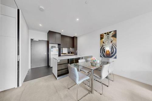 a kitchen and dining room with a glass table and chairs at Elegant Urban Hideaway - Private Luxury Residential Apartment, walk to South Bank & Free Carpark in Brisbane