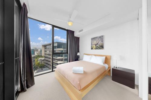 a bedroom with a bed and a large window at Elegant Urban Hideaway - Private Luxury Residential Apartment, walk to South Bank & Free Carpark in Brisbane