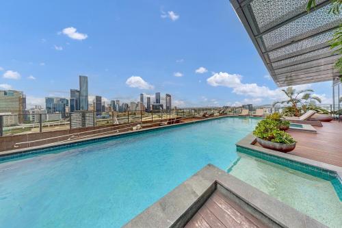 a swimming pool on top of a building with a city skyline at Elegant Urban Hideaway - Private Luxury Residential Apartment, walk to South Bank & Free Carpark in Brisbane