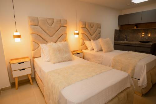 a hotel room with two beds and a kitchen at Santa Barbara Central Suites in Bogotá