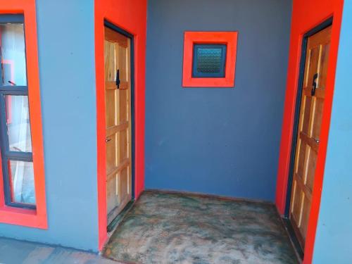 a room with two doors and a blue wall at Ndamu guesthouse in Vosburg