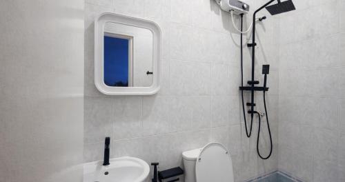a bathroom with a shower and a toilet and a sink at Dhiggaa by H Collection in Huraa