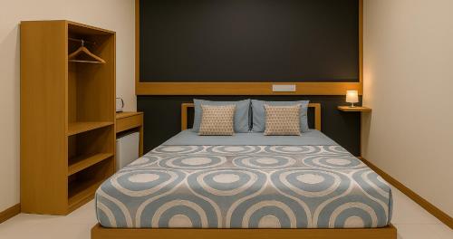 a bedroom with a bed in a room with shelves at Dhiggaa by H Collection in Huraa