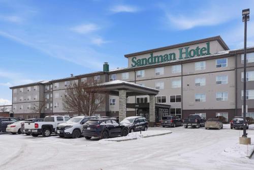 a hotel with cars parked in a parking lot at Sandman Hotel Saskatoon in Saskatoon