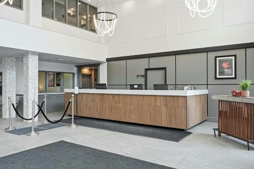 a lobby with a reception desk in a building at Sandman Hotel Saskatoon in Saskatoon