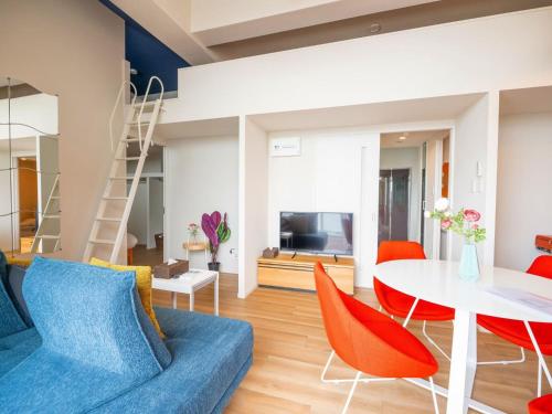 a living room with a blue couch and orange chairs at Hotel Tomas Asahibashi Station in Naha