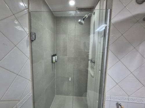 a shower with a glass door in a bathroom at Flat Hotel Executivo Vila Olímpia (Apto 2509) in São Paulo