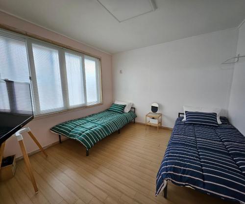 a bedroom with two beds and a piano at 스테이 노랑 stay norang in Daegu