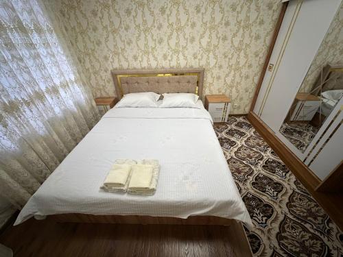 a bedroom with a bed with two towels on it at Karimbek Guest house by SamApart in Samarkand