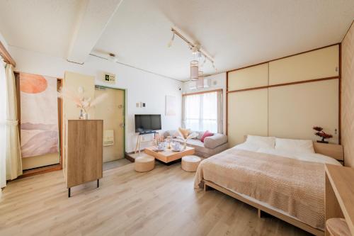 a bedroom with a large bed and a couch at Villa Fuchu Stay in Fuchu