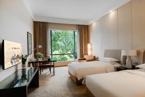 a hotel room with two beds and a window at Jinling Resort Nanjing in Nanjing