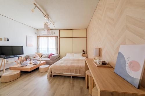 a large room with a bed and a couch at Villa Fuchu Stay in Fuchu