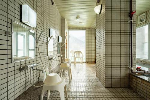 a bathroom with white tile walls and white stools at Fewdays Condominium108 in Sapporo