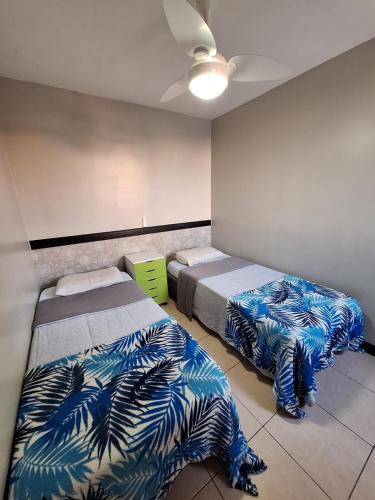 a bedroom with two beds with blue and green blankets at Apto 3 dorms proximo a UFABC e CPTM in Santo André