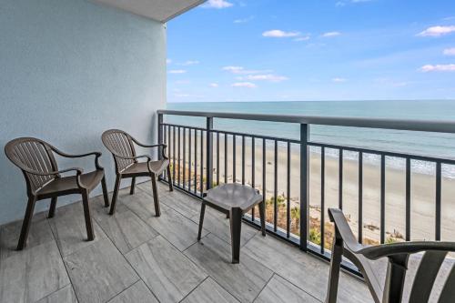 two chairs and a table on a balcony with the beach at Oceanfront,Heated Pools,Boardwalk, Location,Views! in Myrtle Beach