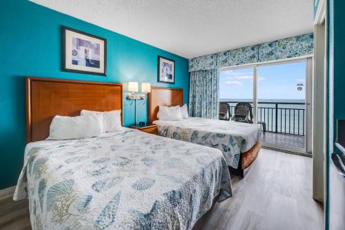 a hotel room with two beds and a balcony at Oceanfront,Heated Pools,Boardwalk, Location,Views! in Myrtle Beach