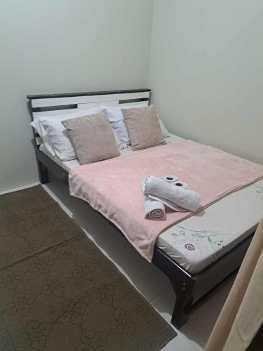 a bed with a pink blanket and pillows on it at Brenthill Condo Ruby unit in Baguio