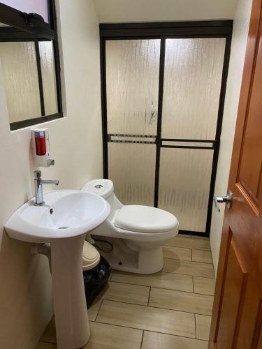 a bathroom with a white sink and a toilet at Casa Colibrí in Bijagua
