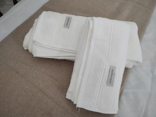 two white towels are sitting on the floor at Quarto privativo em casa compartilhada in Aracaju