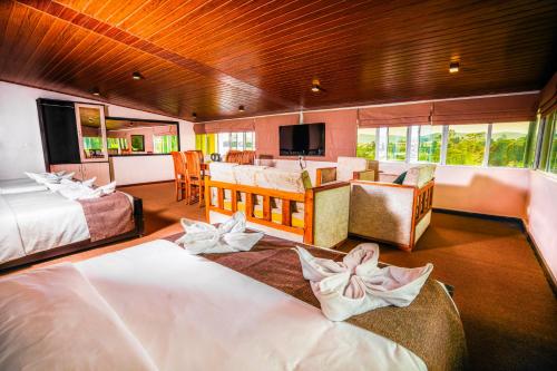 a hotel room with two beds and a living room at La Cottage in Nuwara Eliya