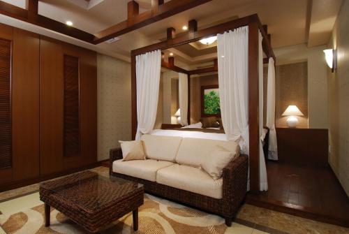 a living room with a couch and a mirror at ホテル アイアンプレミアム 西宮北店 男塾ホテルグループ in Nishinomiya