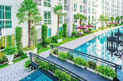 an apartment complex with a swimming pool and palm trees at City Garden Lagoon Pool Apartments with Balcony Pattaya in Pattaya South