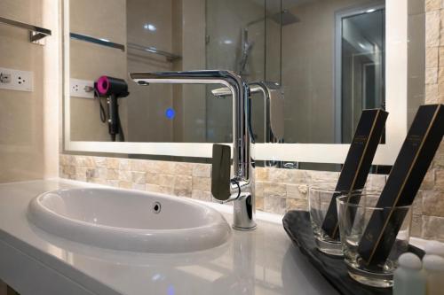 a bathroom sink with a faucet and a mirror at City Garden Lagoon Pool Apartments with Balcony Pattaya in Pattaya South