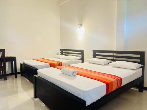 two beds in a room with at Yala Thaman Katharagama in Kataragama