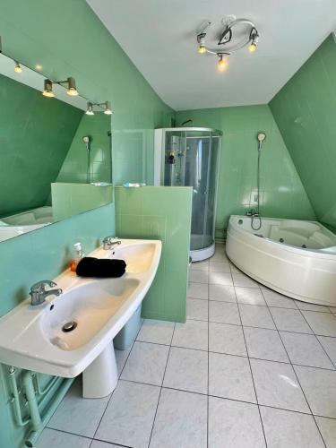 a green bathroom with a tub and a sink and a bath tub at Duplex with Jacuzzi and parking Close to Disney in Lognes