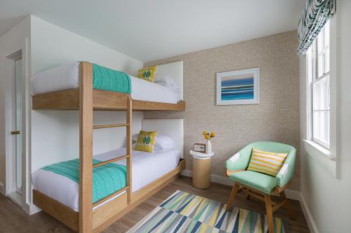 a bedroom with bunk beds and a chair at Summercamp in Oak Bluffs