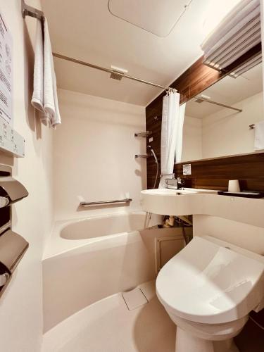 a white bathroom with a toilet and a sink at Osaka03 地铁站步行两分钟 直达难波 日本桥 梅田 关西机场 in Osaka