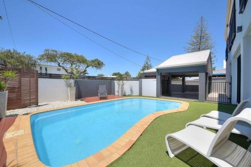 a swimming pool in the backyard of a house with two chairs at Bliss On Pearl Key in Gold Coast