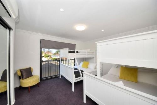 a bedroom with two bunk beds and a balcony at Bliss On Pearl Key in Gold Coast