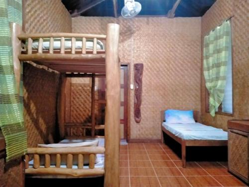 a room with a bunk bed and two beds at JJS BACKPACKERS VILLAGE in Siquijor