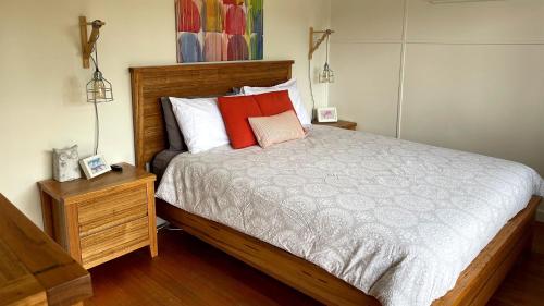 a bedroom with a bed with red and white pillows at Driftwood in Venus Bay