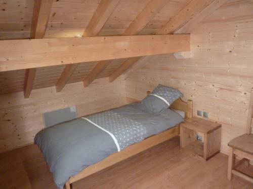 a room with a bed in a log cabin at Le Planot in La Bresse