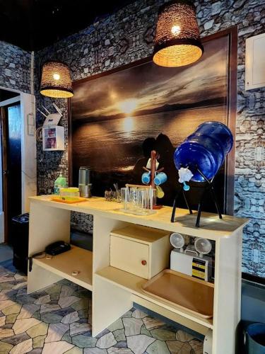 a counter in a kitchen with a painting on the wall at MJs Garden Hotel Moalboal powered by Cocotel in Moalboal