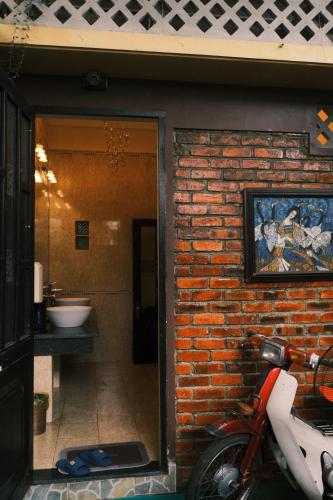 a red motorcycle parked next to a brick wall at Yesterday Homestay Hue in Thôn An Hòa