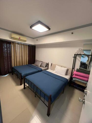 a room with three beds and a window at Sea Residences at Jireh Psalm374 in Pasay