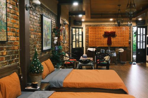 a bedroom with two beds and a brick wall at Yesterday Homestay Hue in Thôn An Hòa