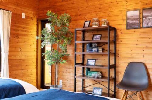 a bedroom with a book shelf and a chair at Wave House Kujukuri Fujishita Near Kujukuri beach- Self Check-In Only in Kujukuri