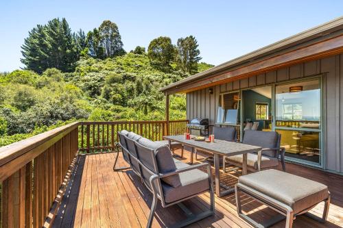 a wooden deck with a table and chairs on it at Kotare Heights in Pohara