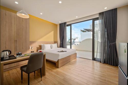 a hotel room with a bed and a desk with a desk at Mai Living Apartment in Danang