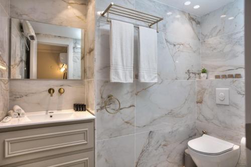 a white bathroom with a sink and a toilet at סוויטות סוויט - Suite in Safed