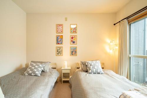 a bedroom with two beds and a window at Fewdays Condominium301 in Sapporo